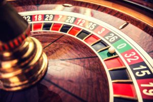 Ruleta en casino con bola en posición cero verde.